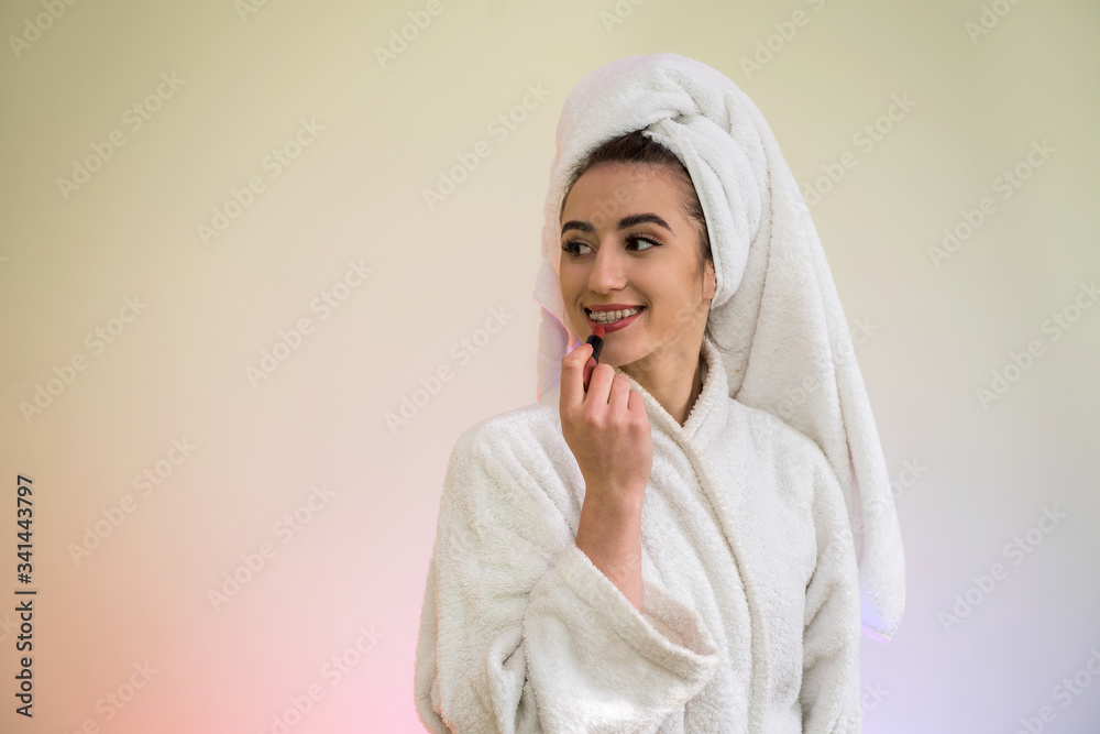 Young beautiful woman doing itself makeover isolated on green Young beautiful woman doing itself makeover isolated on green