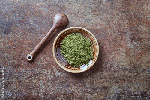 Powdered matcha green tea on rustic stone background. Top view.