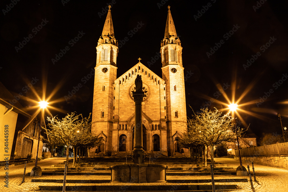 Night lights of park and evangelical church in Forbach village