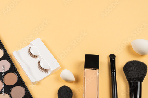 Professional makeup products with cosmetic beauty products, eye shadows, eye lashes, beauty blender, foundation.