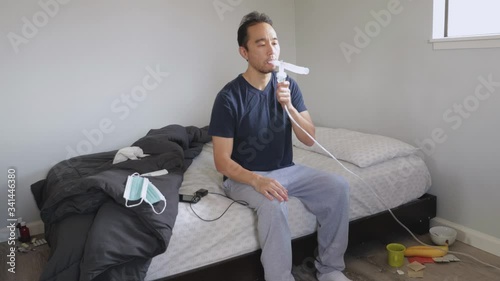 Sick man using nebulizer medication inhaler for asthma, coronavirus, flu photo