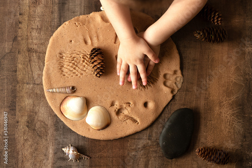 Children play with salt dough on the kitchen table.  Creative lesson with a test of natural products. Development of children in the period of self-isolation