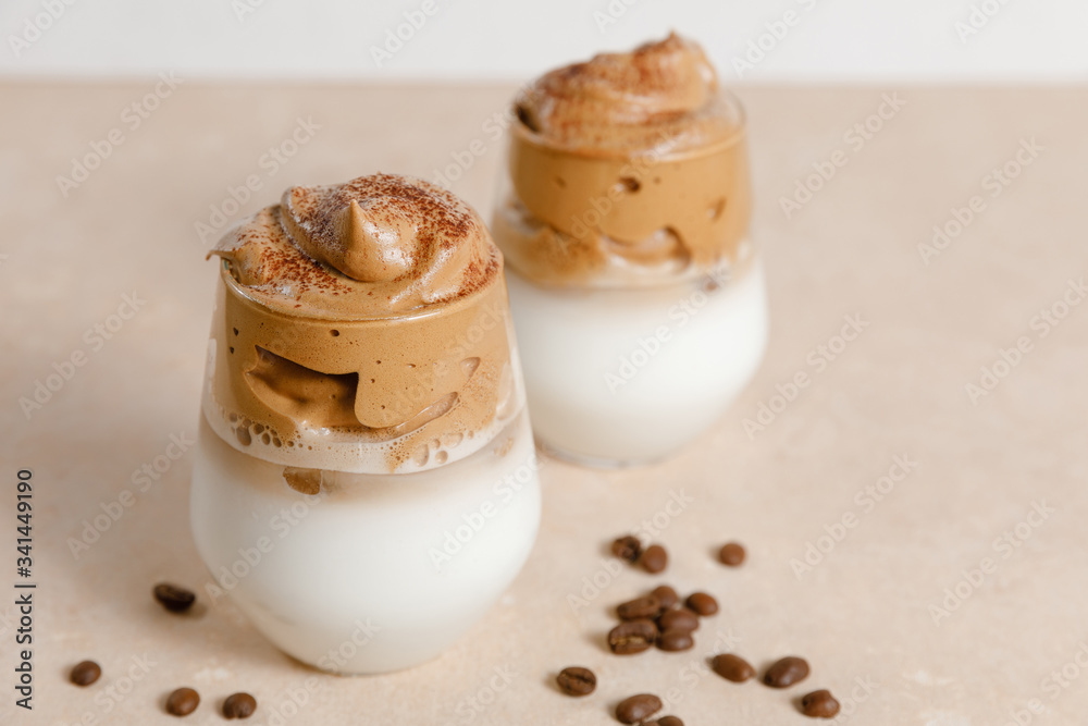 Dalgona coffee - the Korean coffee drink on light beige background. Instant coffee or espresso powder whipped with sugar and hot water Dalgona coffee - the Korean coffee drink on light beige background. Instant coffee or espresso powder whipped with sugar and hot water