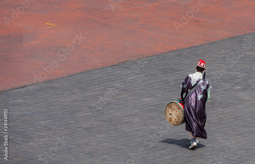 Morocco, Marrakech, Moroccan man backwards with drum at the Place Jemaa-el-Fna (square), copy-space photo