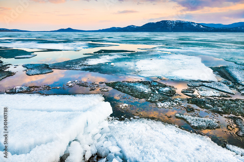 Melting ice on the lake at sunset. Beautiful spring landscape. photo