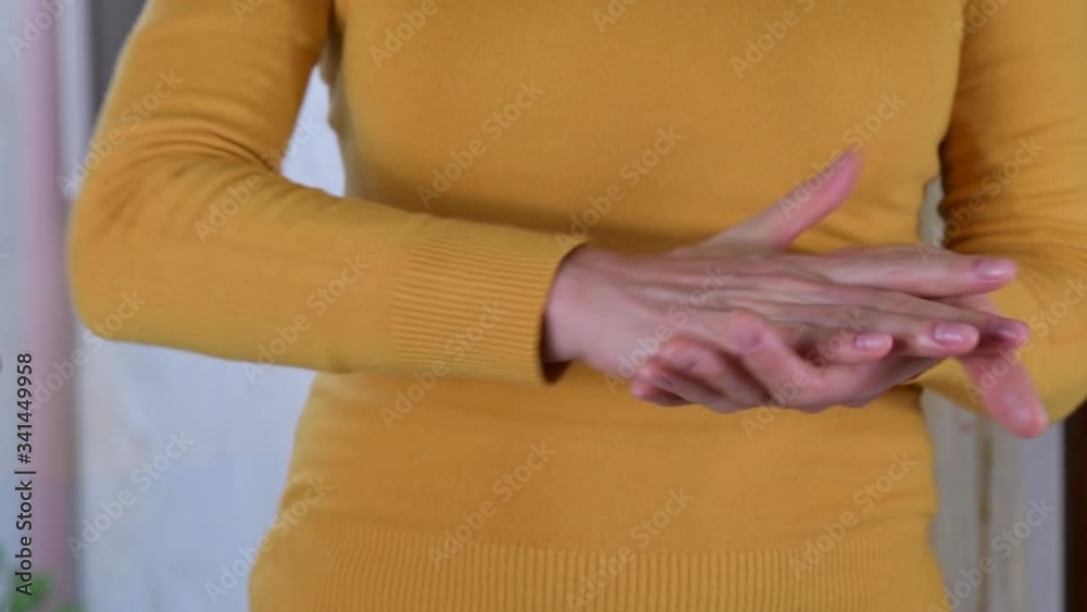 Close up of autenthic female hands are using hand sanitizer gel for corona virus spread prevention. Woman is using alcohol based gel for protection herself from covid-19, showing thumb