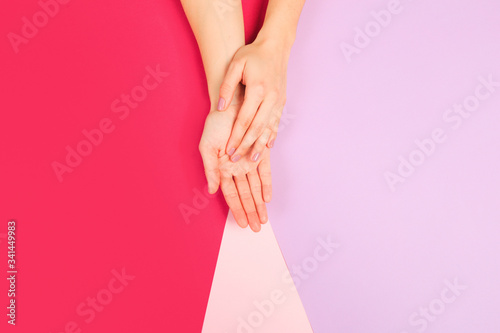 female manicure. Beautiful young woman's hands on color pink background - Image