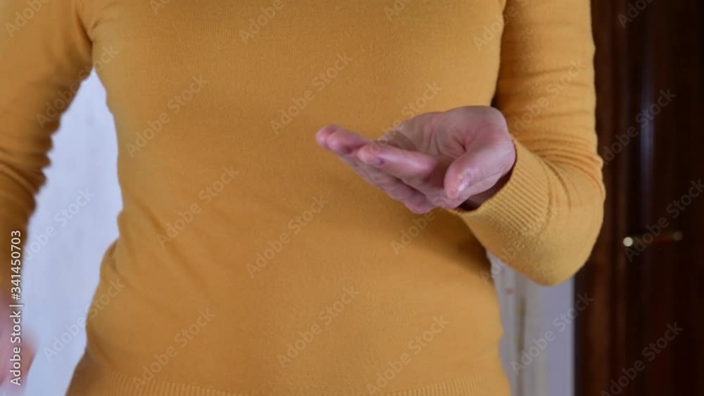 Close up of authentic female hands are using hand sanitizer gel for corona virus spread prevention. Woman is using alcohol based gel for protection herself from covid-19