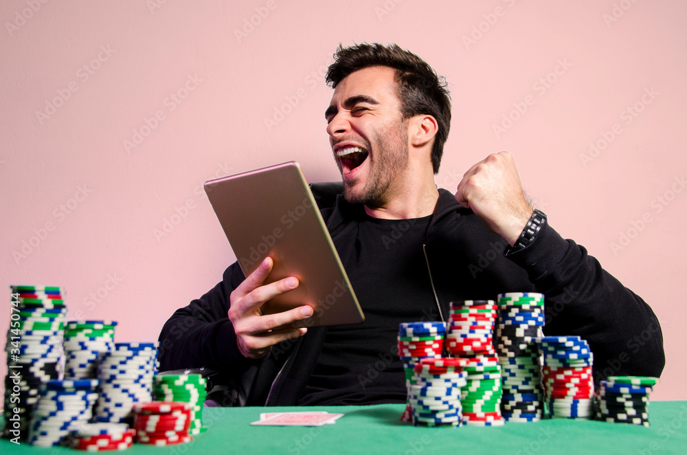 Ecstatic winner in poker game online, man with fist in air celebrating winning game of poker Ecstatic winner in poker game online, man with fist in air celebrating winning game of poker