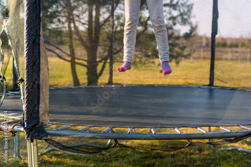 Photography Little girl jumping on the trampoline in the back yard