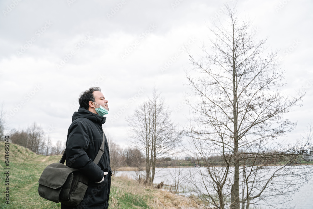 Man with face mask removed enjoying fresh air in the nature Man with face mask removed enjoying fresh air in the nature