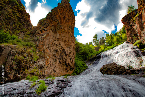 waterfall and rock with trees aunder sky photo