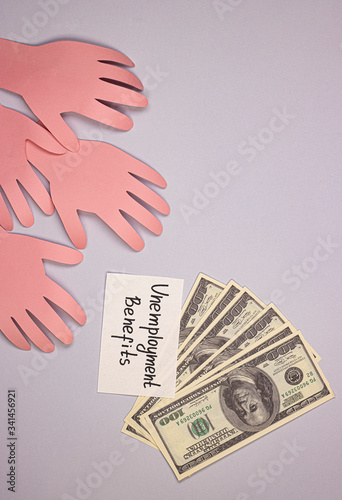 many hands from paper reach for money and the inscription unemployment benefit. the concept of issuing insurance payments to people who lost their jobs due to covid-19