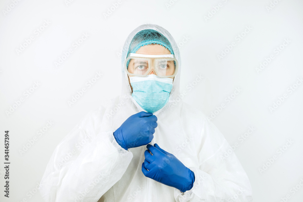portrait of tired doctor after shift in the hospital. The doctor in protective clothing - glasses, mask, gloves on white background. The doctor treating patients with coronavirus. Covid-2019 portrait of tired doctor after shift in the hospital. The doctor in protective clothing - glasses, mask, gloves on white background. The doctor treating patients with coronavirus. Covid-2019