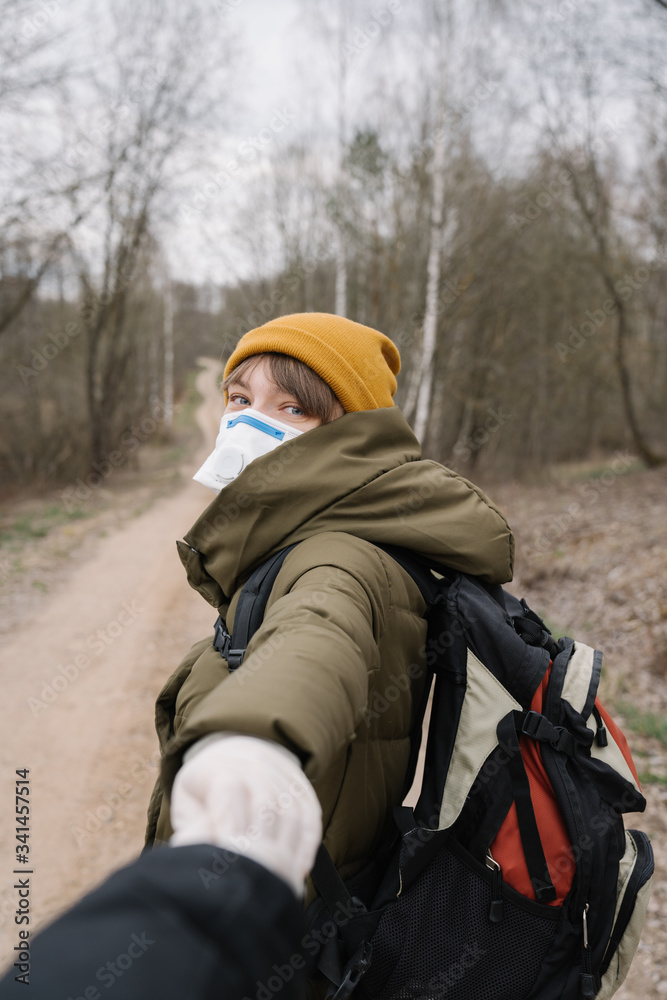Woman wearing face mask and disposable gloves holding hand of another person