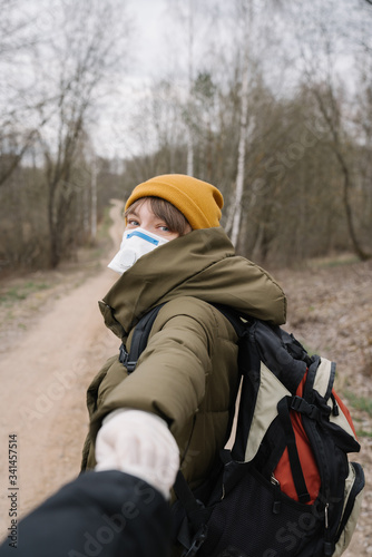 Woman wearing face mask and disposable gloves holding hand of another person © Jevgenija