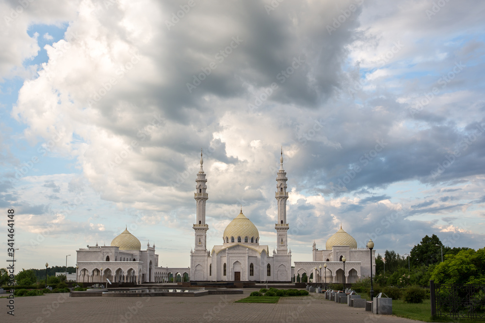 Beautiful white mosque in the city of Bulgar on the background of a beautiful sky with a green meadow in the foreground