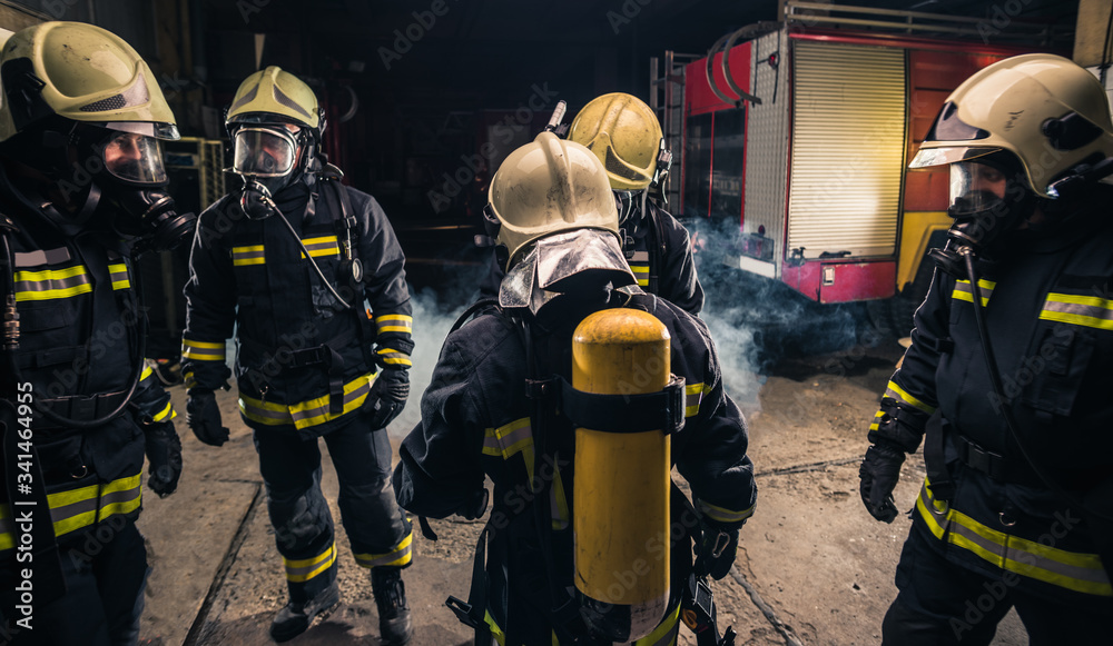 Group of firefighters in the fire department checking their gas mask equipment Group of firefighters in the fire department checking their gas mask equipment