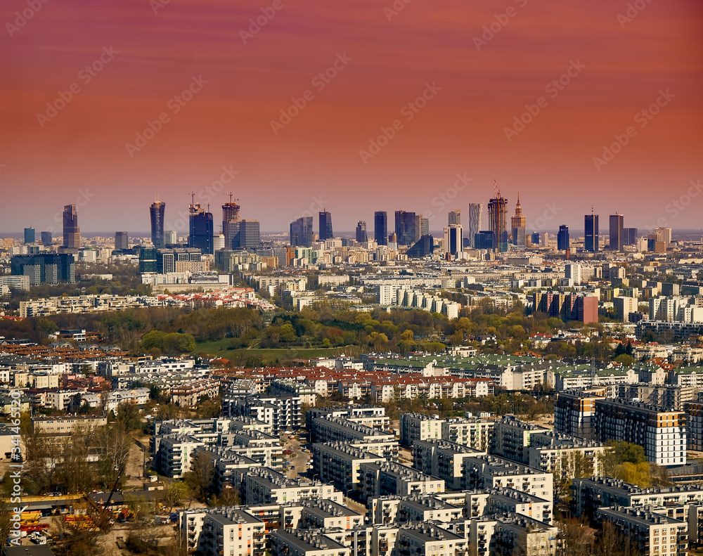 Fototapeta premium Beautiful panoramic aerial cityscape - view from the window of the plane landing at the center of Warsaw (Poland) with skyscrapers, with parks and residential areas, spring at sunset