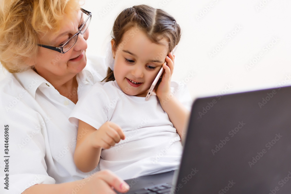 little girl and grandmother learning online on laptop little girl and grandmother learning online on laptop