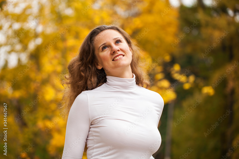 Portrait of a young beautiful girl in autumn park