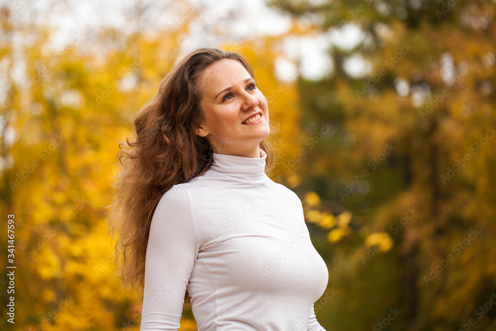 Portrait of a young beautiful girl in autumn park