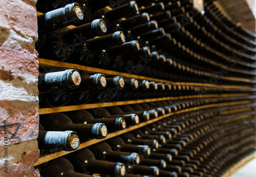 Red wine bottles stored in a wine cellar of a winery
