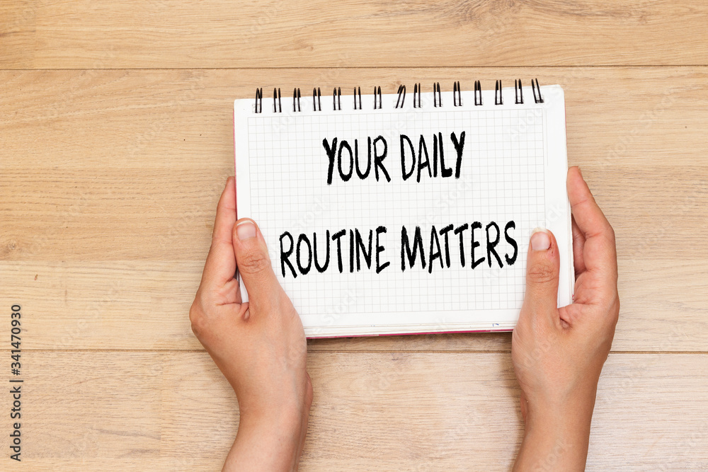hands holding notebook with Your Daily Routine Matters concept for practice of regularly hands holding notebook with Your Daily Routine Matters concept for practice of regularly