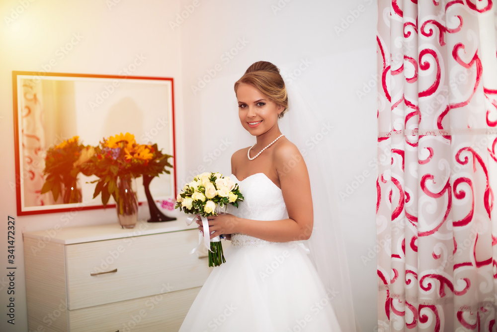 A elegant and beautiful bride at home standing near window A elegant and beautiful bride at home standing near window