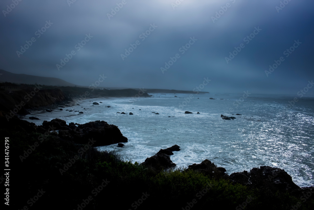 Obraz premium Moody Sunrise Under Fog with Breaking Surf in California