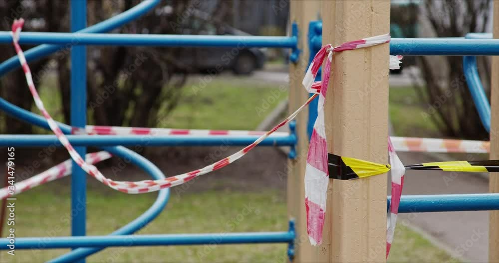 Playground closed by striped tape fencing for quarantine during the coronavirus epidemic