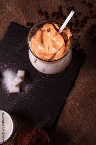 Cold trendy drink Korean dalgon iced coffee on a dark background. delicious and popular coffee in the trend photo