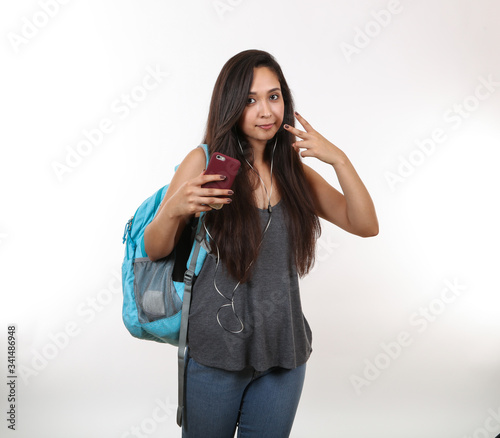 Girl Wearing Backpack and Earphones Says Peace
