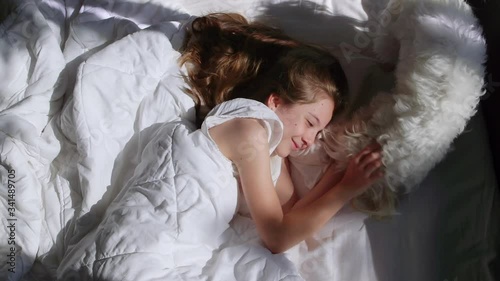 Little Girl her Pet Wake up in the Morning Sunlight. White Happy Dog.