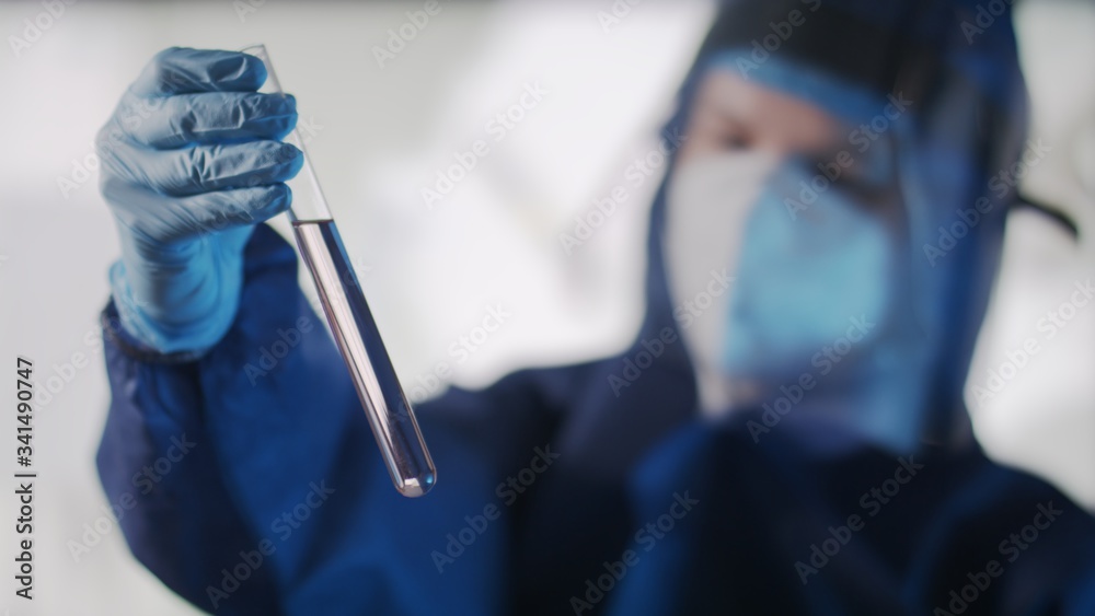 Female scientist shaking optical glass test tube cuvettes. Coronavirus research, vaccine development and microbiology research Female scientist shaking optical glass test tube cuvettes. Coronavirus research, vaccine development and microbiology research