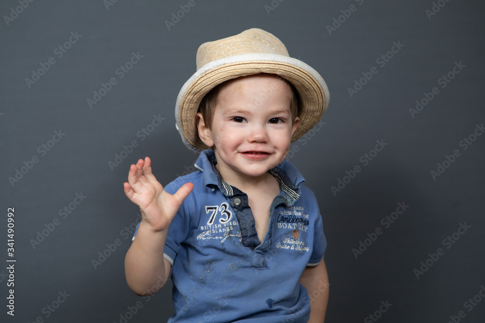 Portrait of a small laughing boy on a gray background Portrait of a small laughing boy on a gray background