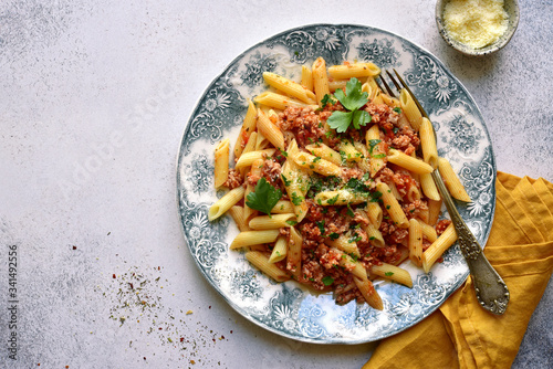 Penne pasta with bolognese sauce - traditional recipe of italian cuisine. Top view with copy space.