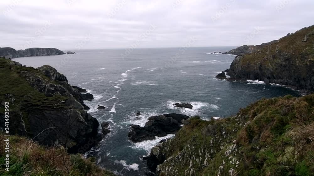 Beautiful high view of cliff and the coast with waves crashing with the rocks Beautiful high view of cliff and the coast with waves crashing with the rocks