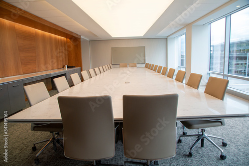 Empty conference room table with more than 20 chairs in a contemporary setting