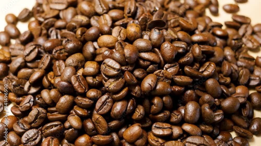 Coffee beans roasted. Close up of seeds of coffee. Macro shot. Falling coffee beans. Coffee beans roasted. Close up of seeds of coffee. Macro shot. Falling coffee beans.