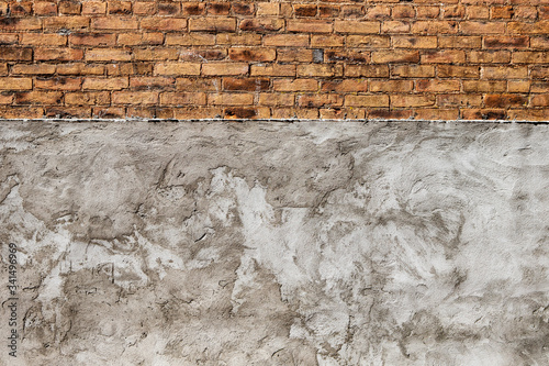 Yellow and Brown beautiful brick wall above heavely textured stucco concrete grey wall background