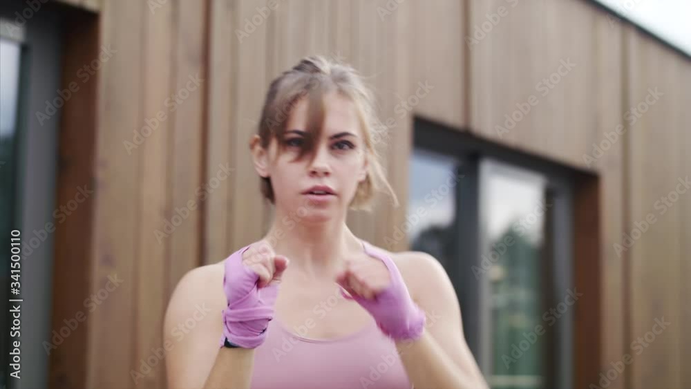 Young woman doing exercise outdoors on terrace, boxing. Young woman doing exercise outdoors on terrace, boxing.