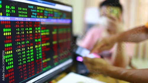 Stock exchange market business. Display of Stock market quotes with blurry red graph on smartphone and the patient is wearing a mask. The concepts of the economic downturn from Covid 19.