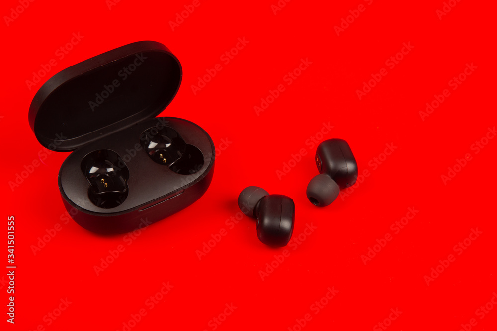 Wireless bluetooth headphones isolated on red background