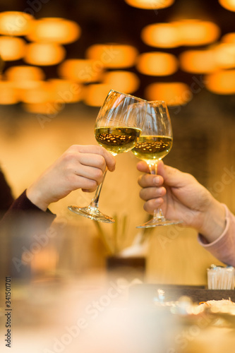 Clinking glasses with white wine and toasting.