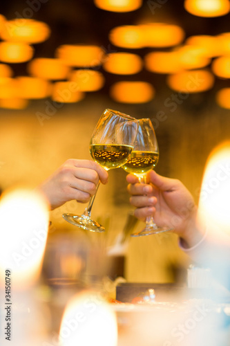 Clinking glasses with white wine and toasting.