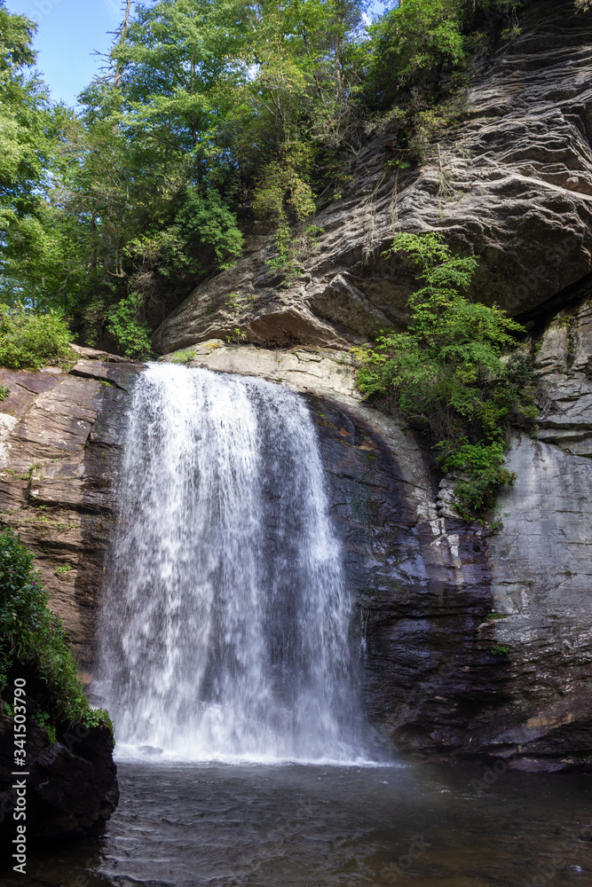 Beautiful summer landscape with a waterfall.  A large waterfall among the huge cliffs overgrown with trees. Looking Glass Fall, NC, USA