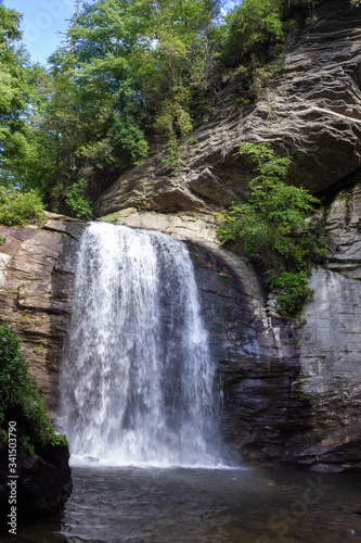 Beautiful summer landscape with a waterfall.  A large waterfall among the huge cliffs overgrown with trees. Looking Glass Fall  NC  USA