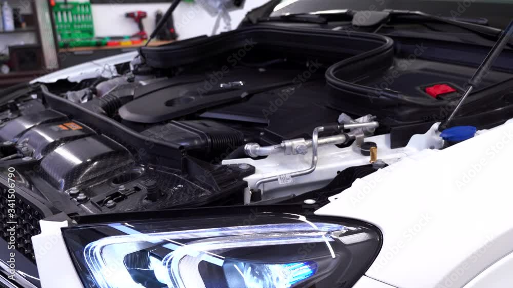 Video of a powerful car engine of new car, loud sound of an SUV motor, jeep, car driving, open hood, car headlight, radiator, power, luxury, expensive business class vehicle