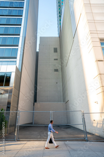 Man with package walks in front of empty building space for a Manhattan building 